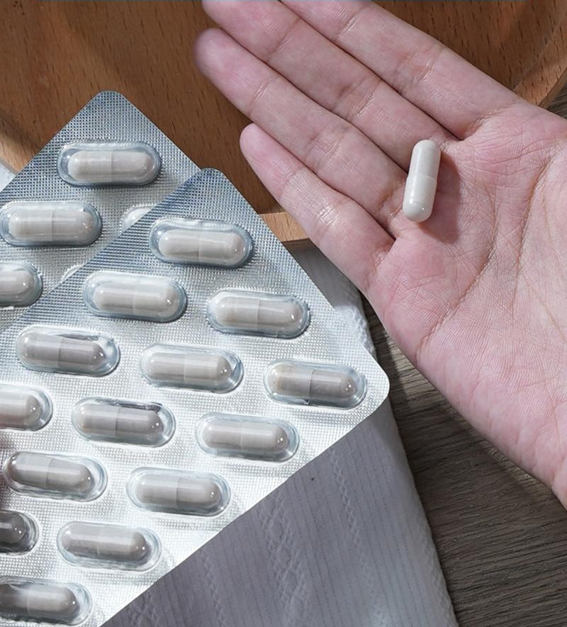 Pyloblast capsules in individual foil blister packs, with one capsule in an open hand