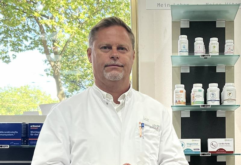 Pharmacist in a dispensary, with Pyloblast MagenVital on the shelf behind